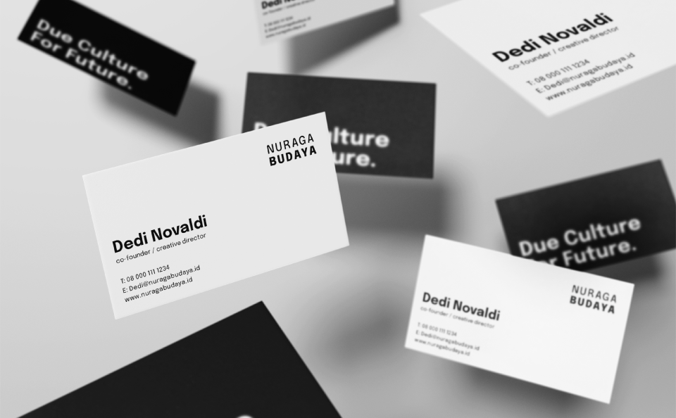 Visualisation of Nuraga Budaya business cards. Business cards fly in the air and alternately reveal the front side with black text on a white background and the back side with a claim on a black background.