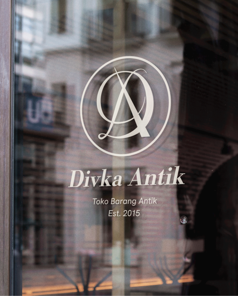 The Divka Antik logo is placed on the shop's glass door.